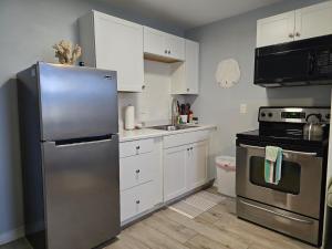a kitchen with a stainless steel refrigerator and a stove at Seahorse - Tiny Home 1.2 Mi, 2 Beach Kitchen W & D Queen Bed in Bonita Springs