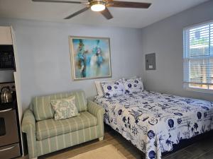 a bedroom with a bed and a couch and a ceiling fan at Seahorse - Tiny Home 1.2 Mi, 2 Beach Kitchen W & D Queen Bed in Bonita Springs