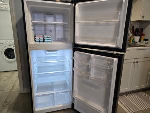 - un réfrigérateur vide avec une porte ouverte dans la cuisine dans l'établissement Seahorse - Tiny Home 1.2 Mi, 2 Beach Kitchen W & D Queen Bed, à Bonita Springs