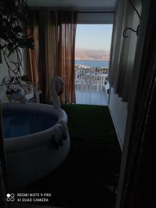 a room with a bath tub with a swan on the floor at Eilat in Eilat