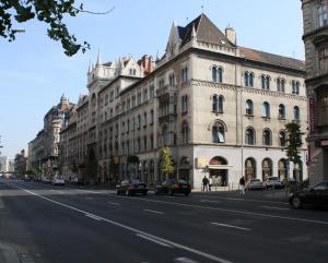 duży budynek z samochodami zaparkowanymi przed ulicą w obiekcie Luther Boutique Homes Downtown w Budapeszcie