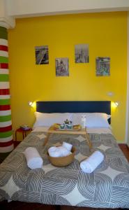 een bed met witte kussens en een gele muur bij Guest House Guicciardini in Reggio Emilia
