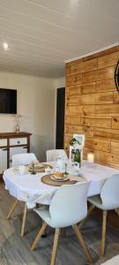 a dining room table with white chairs and a white tablecloth at Au Jardin d'Edel Gîtes Centre Alsace in Dieffenthal