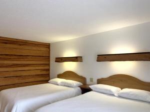 2 camas en una habitación de hotel con sábanas blancas en Listing to be removed, en Tomahawk