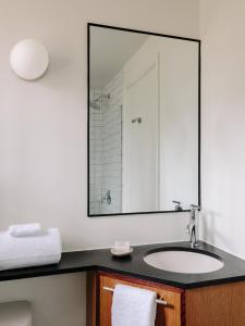 a bathroom with a sink and a large mirror at The Outpost Rocky Mountains in Estes Park +34 photos