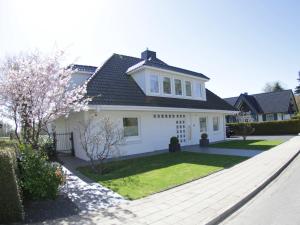 ein weißes Haus mit einem angelegten Garten in der Unterkunft Techts Landhus Birkenallee in Timmendorfer Strand