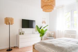 1 dormitorio con 1 cama y TV en la pared en Moderne Stadtwohnung im Zentrum von Bottrop!, en Bottrop