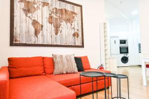 uma sala de estar com um sofá laranja e um mapa na parede em For You Rentals Acogedor Apartamento de Dos Dormitorios en Madrid HDB12 em Madri