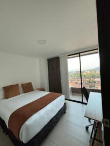 a bedroom with a large bed and a large window at Alojamiento en El Carmen de Viboral in Carmen de Viboral