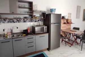 a kitchen with a stainless steel refrigerator and a table at novinha, aconchegante e moderna! in Londrina