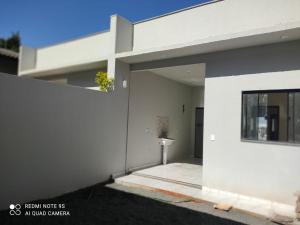 a white house with a window and a building at novinha, aconchegante e moderna! in Londrina