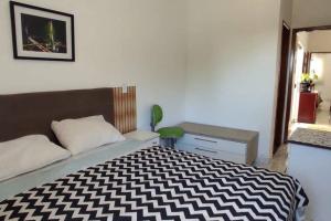 um quarto com uma cama com um cobertor preto e branco em novinha, aconchegante e moderna! em Londrina