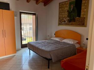 a bedroom with a bed and a painting on the wall at Agriturismo Rocca Dei Marchesi in Sabbio Chiese