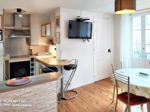 ルションにあるAppartement de 2 chambres a Bagneres de Luchonのキッチン(テーブル、壁掛けテレビ付)