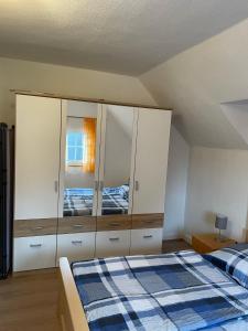 una camera con letto e armadietto bianco di Ferienhaus Pacco a Wermelskirchen
