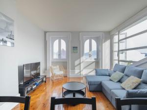 ein Wohnzimmer mit einem blauen Sofa und einem TV in der Unterkunft Apartamento Vigo, 3 dormitorios, 7 personas - ES-210-2 in Vigo