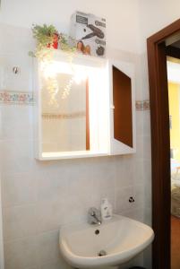 een badkamer met een wastafel en een spiegel bij Guest House Guicciardini in Reggio Emilia