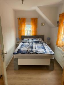 a bedroom with a bed with a blue and white comforter at Ferienhaus Pacco in Wermelskirchen