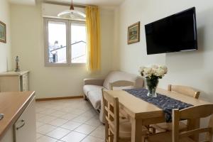 ein Wohnzimmer mit einem Tisch und einem Sofa in der Unterkunft Residence Tre Trilo&Suites in Rimini