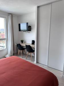 a bedroom with a bed and a table with chairs at Le Cocon - proche gare et centre ville in Lourdes