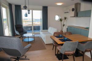 a living room with a couch and a table and chairs at Residentie Oosterschelde in Sint Philipsland