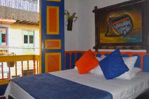 1 dormitorio con 1 cama con almohadas coloridas en FILANDIA HOTEL, en Filandia