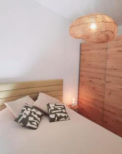 1 dormitorio con 1 cama con almohadas y lámpara en Quinta das Pedras - Tavira, en Tavira