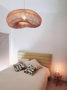 a bedroom with a bed with pillows and a chandelier at Quinta das Pedras - Tavira in Tavira