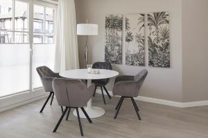 a dining room with a white table and chairs at Techts Strandhaus in Timmendorfer Strand