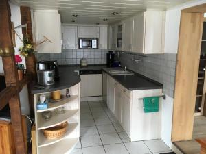 a kitchen with white cabinets and a counter top at Ferienhaus Pacco in Wermelskirchen