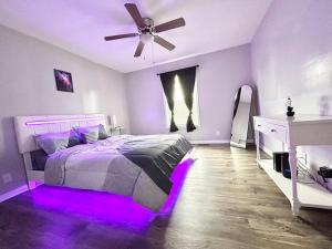 een slaapkamer met een bed met paarse verlichting bij The Urban Oasis in Clarksville