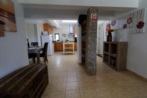 a kitchen and a living room with a table at Private 2-bedroom apartment & private solar heated pool WiFi, AC in Tábua