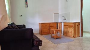 sala de estar con fregadero, mesa y silla en Meru Farm House, en Arusha