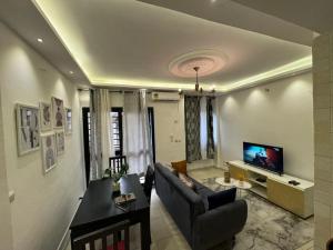 a living room with a couch and a television at Résidence cosy gold Douala Cameroon in Douala