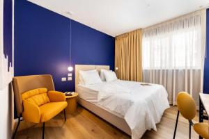 a bedroom with a bed and a blue wall at Sirkin 16 Hotel - Autonomous hotel in Giv‘atayim +7 photos