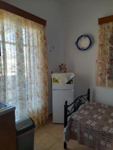 - une chambre avec un lit et une fenêtre avec des rideaux dans l'établissement ELZAHED MAESTRO, à Kimolos