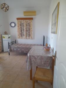 - une salle à manger avec une table et un lit dans l'établissement ELZAHED MAESTRO, à Kimolos