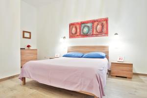 - une chambre avec un grand lit blanc et des oreillers bleus dans l'établissement Angolo Marconi Seaside Apartment, à Salerne