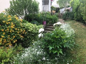 einen Garten mit Blumen und Treppen vor einem Haus in der Unterkunft Ma demeure in Le Gué-de-Longroi