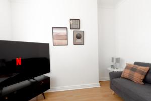 a living room with a couch and a piano at Liverpool Delight: Cosy Single Room in Liverpool