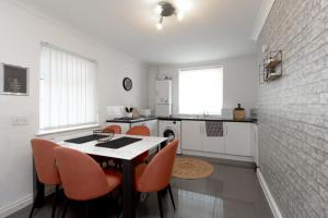 a kitchen with a table and orange chairs at Liverpool Delight: Cosy Single Room in Liverpool