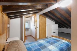 a bedroom with a blue bed and wooden ceilings at Casa Vacanze Il Torchio in Calice al Cornoviglio
