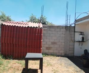 a bench in front of a red fence at Loft Volcanes in Amecameca de Juárez