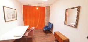 ein Wohnzimmer mit einem Spiegel und einem blauen Stuhl in der Unterkunft Helles Zimmer im Loft in Mannheim