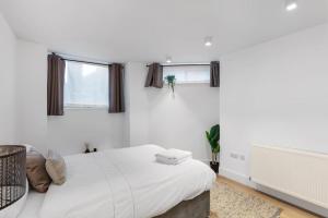 una camera bianca con un letto e due finestre di Bank/Monument apartment a Londra
