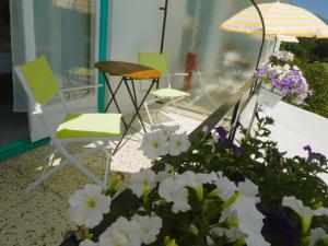 grupa krzeseł i kwiatów na ganku w obiekcie Villa Rauter w mieście Seeboden