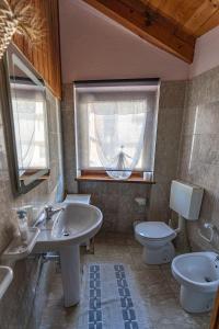 ein Bad mit einem Waschbecken, einem WC und einem Fenster in der Unterkunft Excenex Apartment in Aosta
