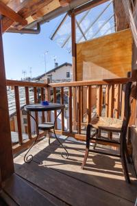 einen Tisch und einen Stuhl auf einem Holzbalkon in der Unterkunft Excenex Apartment in Aosta