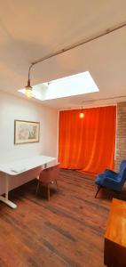 ein Büro mit einem Tisch, Stühlen und einem roten Vorhang in der Unterkunft Helles Zimmer im Loft in Mannheim