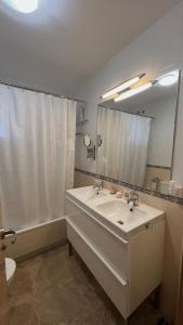 een badkamer met een wastafel, een toilet en een spiegel bij Casa Bignonia in Salteras